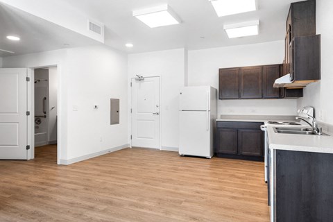 an empty kitchen and living room with white walls and wood floors